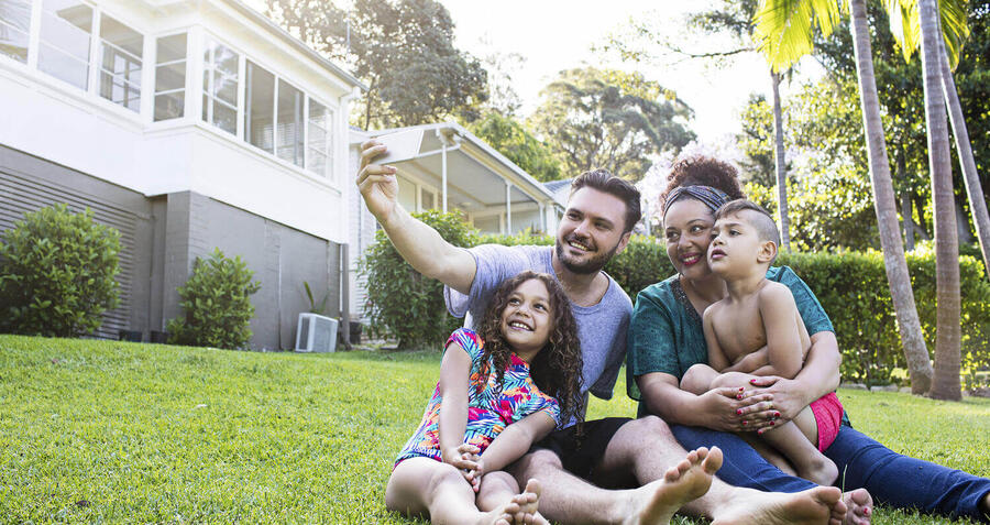 Family take selfie outside their new dream house 