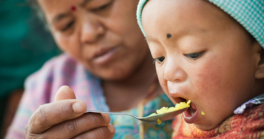 Asian woman feeding a child