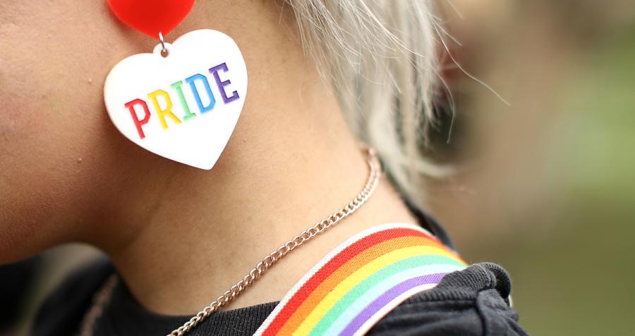 Woman with rainbow suspenders and pride earring